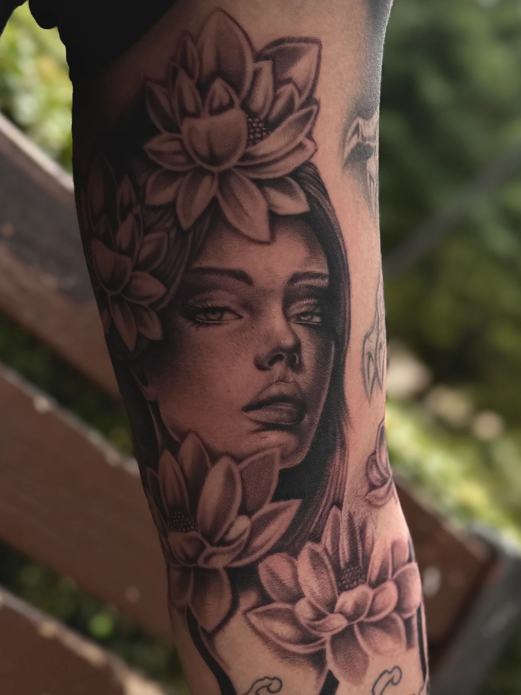 Woman's face with lotus flowers on the forearm