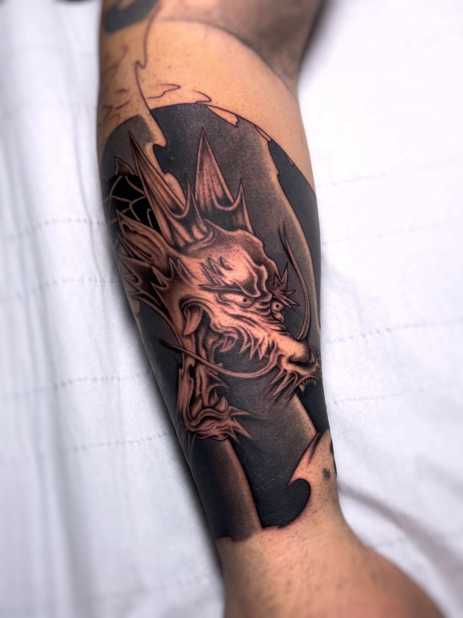 Dragon on a black background on the forearm