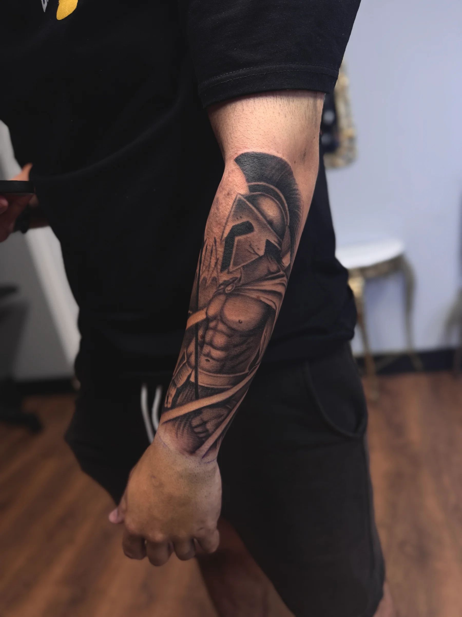 Guerrero con casco espartano en el brazo