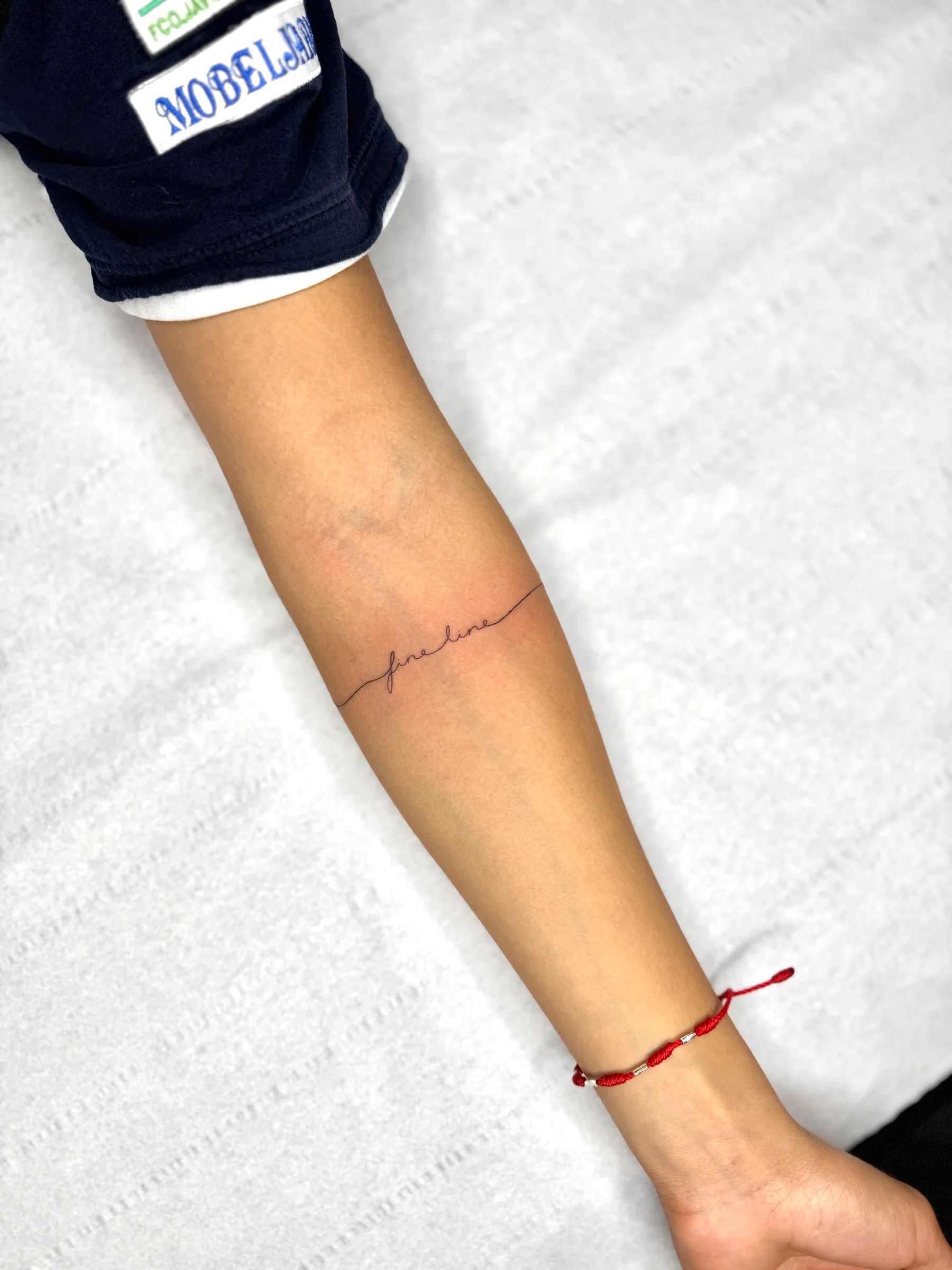 Una palabra en letra fina en el antebrazo