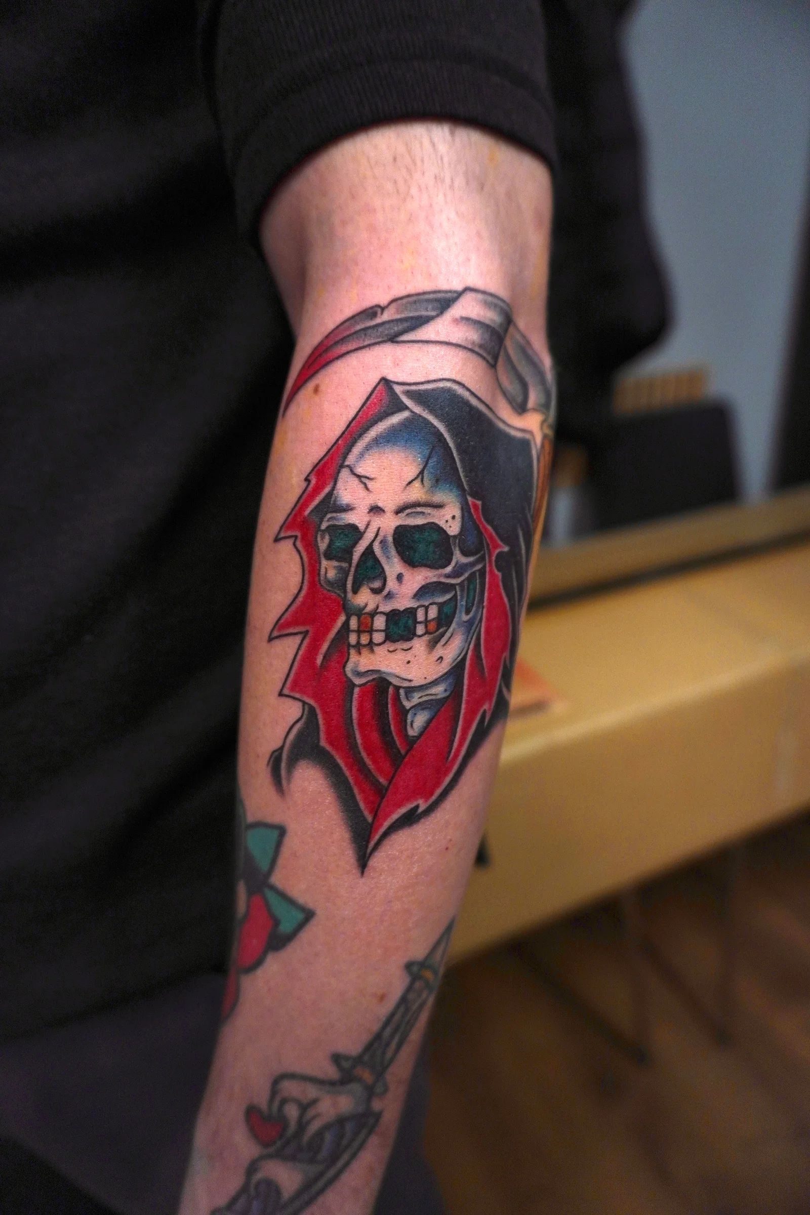 Skull with a red hood on the forearm
