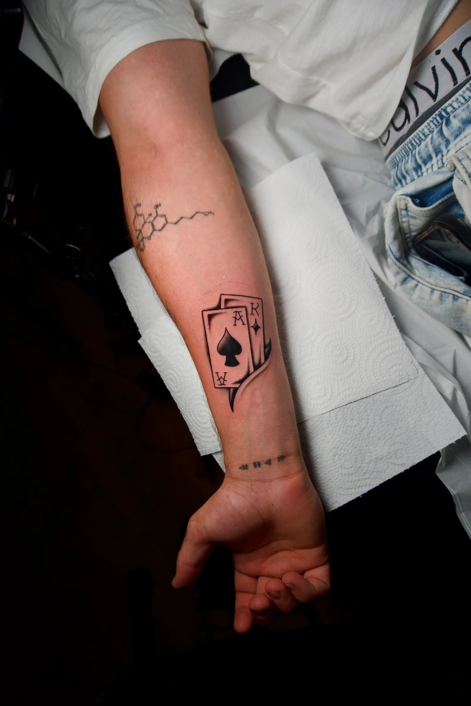 Playing cards with the ace of spades on the forearm
